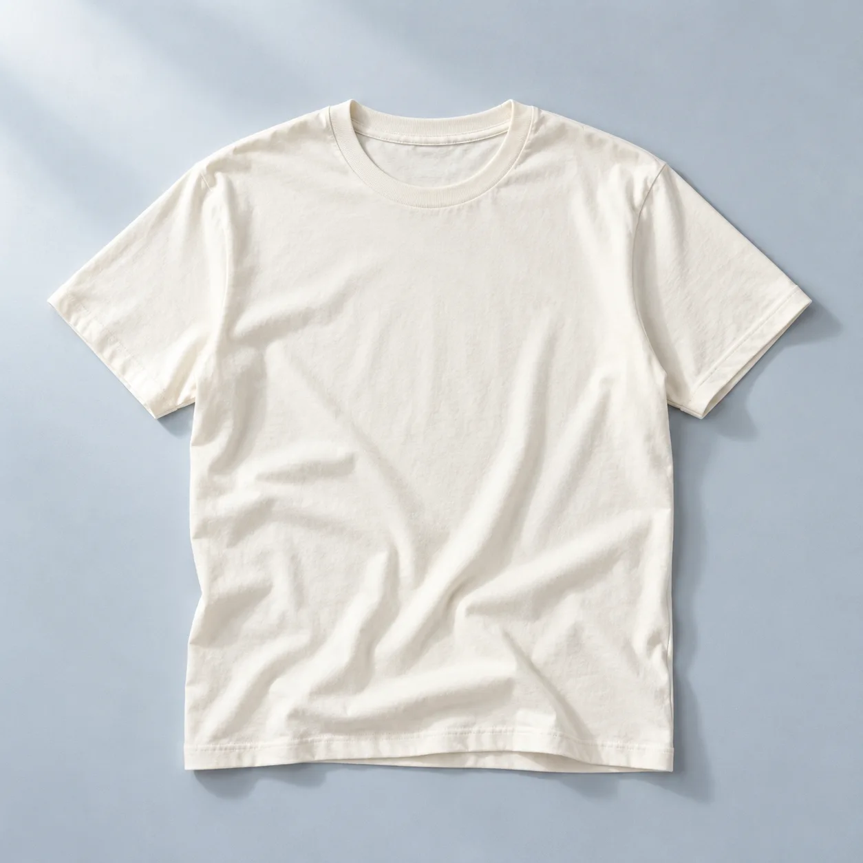 Camiseta de algodão cor marfim sobre um fundo azul claro